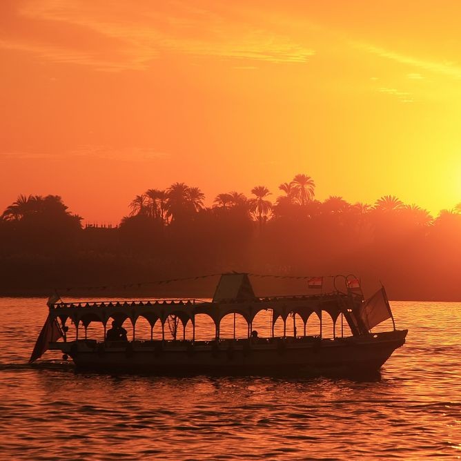 A Boat cruising on the Nile River at sunset, near Luxor, Egypt © Donyanedomam | Dreamstime 33948732