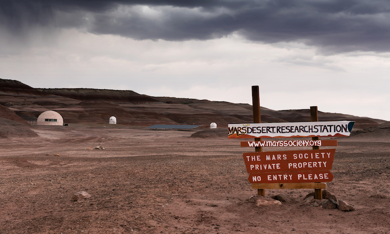Plates " marsdesertresearchstation", "www.marssociety.org", " The Mars Society private property", "No entry please" on the background of the Mars Desert Research Station (MDRS)